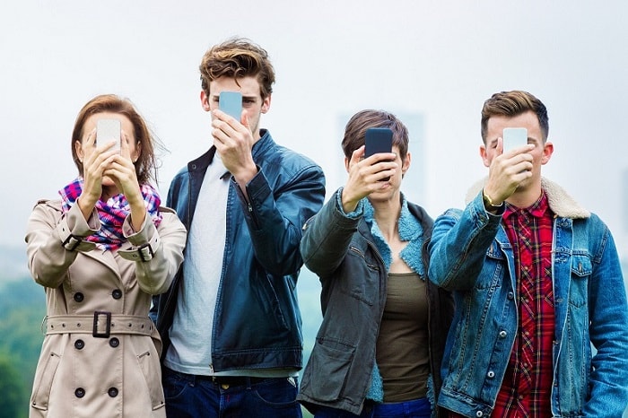 four people looking at mobile