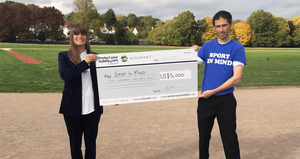 Protect Your Bubble cheque presentation for Sport in Mind Protect Your Bubble present Neil Harris of Sport in Mind with a cheque from Assurant's global steps challenge